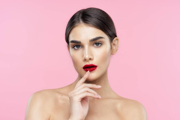 Portret van een mooie jonge vrouw met rode lippenstift op haar lippen. Schoonheid, mode fotografie  - Foto, afbeelding