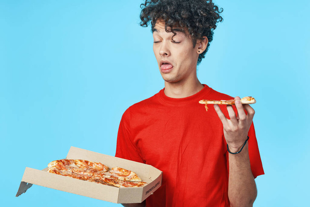 joven guapo hombre con pizza en estudio - Foto, Imagen