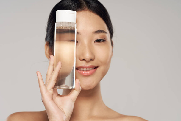 beautiful asian woman holding bottle, beauty product  - Фото, изображение
