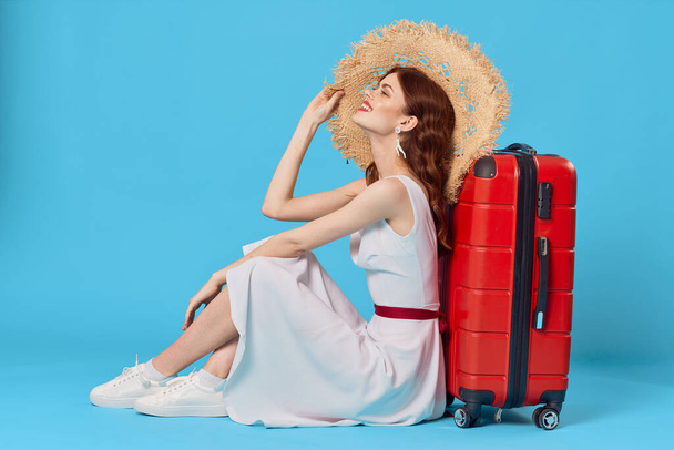 Giovane donna con valigia rossa in studio - Foto, immagini