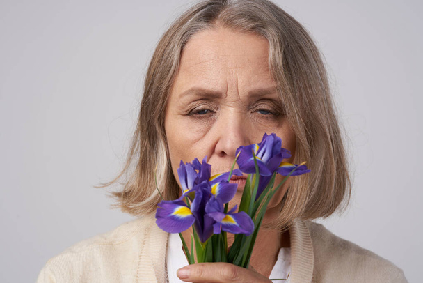 Belle femme âgée avec des fleurs en studio - Photo, image