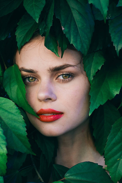 Young beautiful woman posing with leaves around her face - Foto, Bild