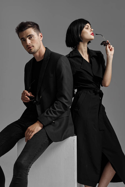 Young beautiful couple in black posing in studio - Фото, изображение