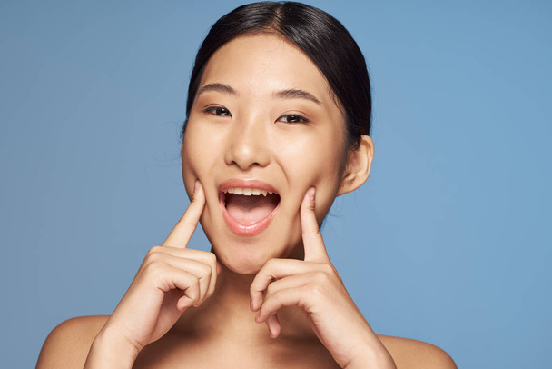 Prise de vue. Jeune asiatique femme pointant joues  - Photo, image