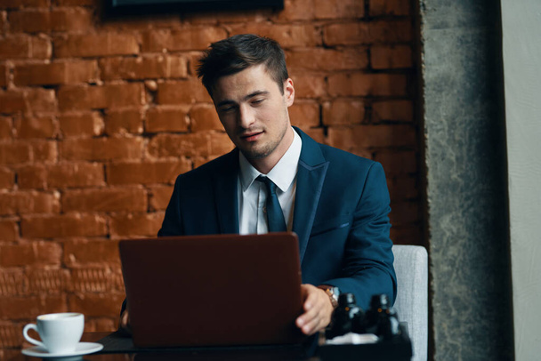 молодой бизнесмен с ноутбуком в офисе  - Фото, изображение