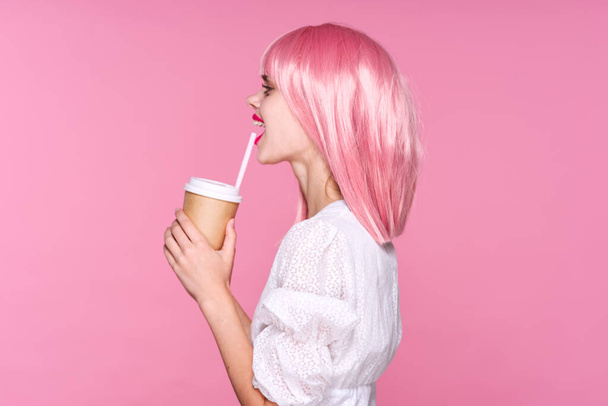 joven hermosa mujer en rosa peluca posando con taza de café
 - Foto, imagen