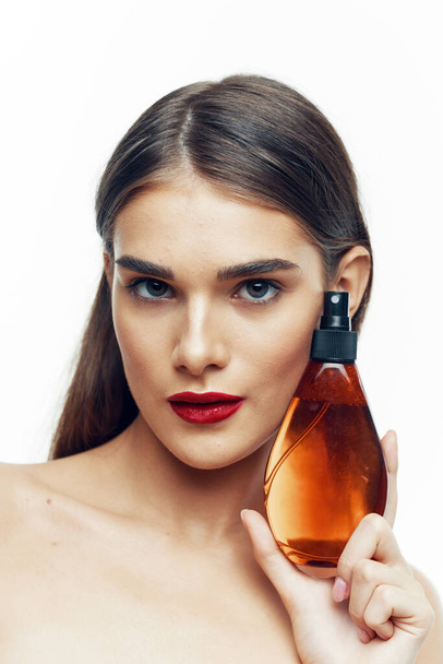 Young beautiful woman with beauty product  in studio  - Foto, Imagen