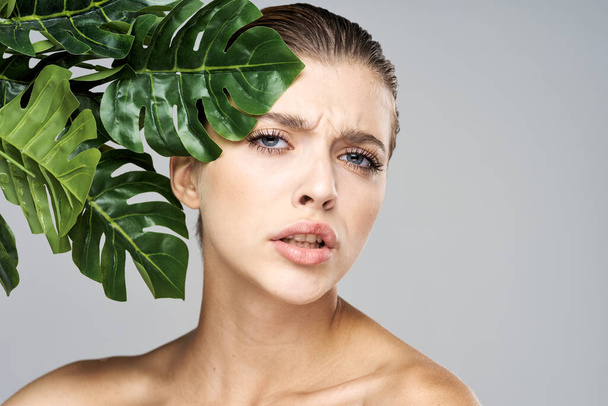 Молодая красивая модель позирует с листьями в студии
 - Фото, изображение