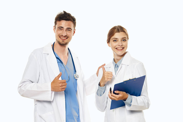 Νεαρός γιατρός και νοσοκόμα με αντίχειρες επάνω στο στούντιο, απομονωμένο υπόβαθρο.  - Φωτογραφία, εικόνα