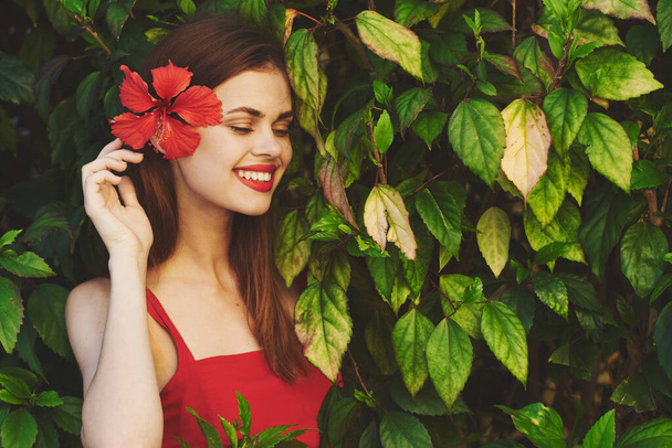 Joven hermosa mujer posando con la flor en su pelo mirando hacia otro lado  - Foto, Imagen