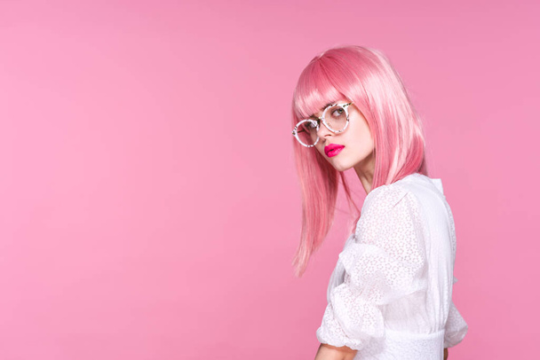 fiatal nő rózsaszín paróka és szemüveg rózsaszín háttér - Fotó, kép