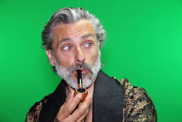 ローブを着た大人の男喫煙パイプ - 写真・画像