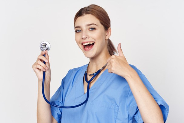 portrait of young beautiful woman doctor with stethoscope showing  thumb up, isolated background - Photo, Image