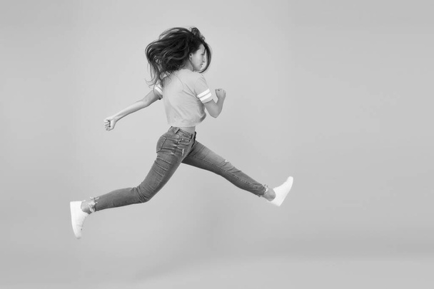 Energetic woman running or jumping. Skinny jeans suits her. Sexy girl yellow background. Sensual girl in casual style. Feel inner energy. Pretty girl with long hair. Fashion style. Beauty and make up - Φωτογραφία, εικόνα