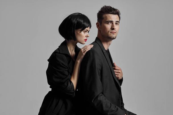 Jovem casal bonito em preto posando em estúdio
 - Foto, Imagem
