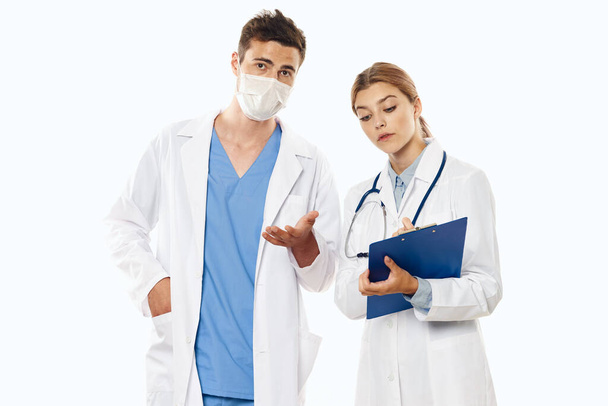 Młodzi lekarze w studiu, odizolowani. kobieta trzyma flip board  - Zdjęcie, obraz