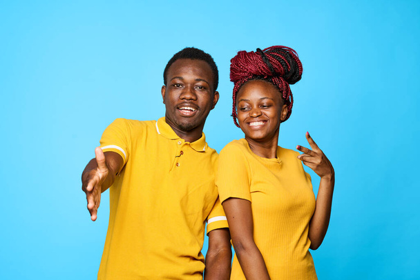 young beautiful couple posing in studio on blue background - Foto, Imagem