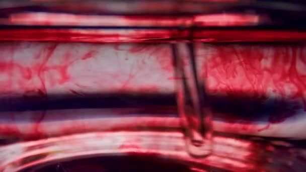 Makro probówki z krwią. Mieszanie czerwonego płynu w wyrobach szklanych z pipetą - Materiał filmowy, wideo
