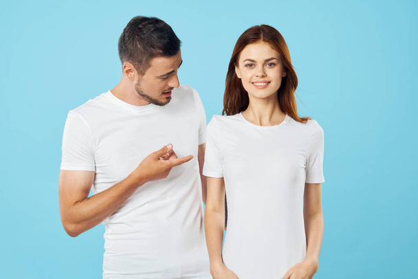 young beautiful couple in  t-shirts posing in studio on isolated background - Fotoğraf, Görsel