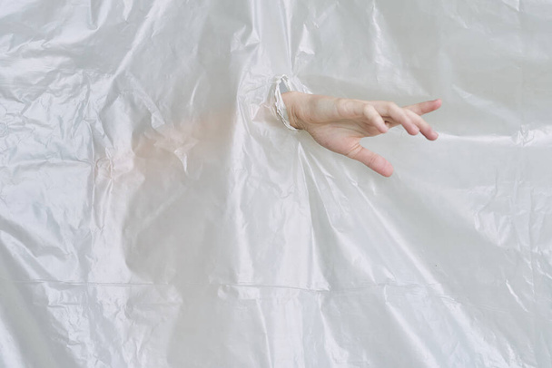 女性の手がプラスチックを引き裂きポリエチレン - 写真・画像