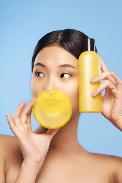 Young beautiful asian woman  holding beauty products  isolated  - Foto, immagini