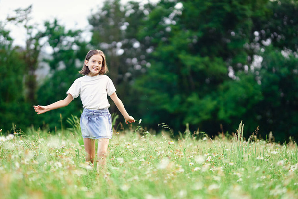 Young cute girl having fun on meadow - Фото, зображення