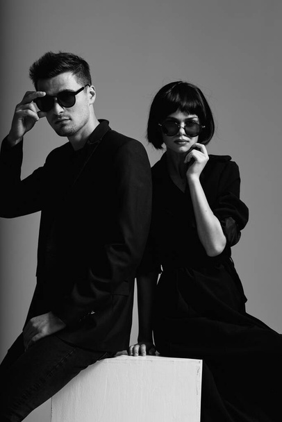 Junges schönes Paar mit Sonnenbrille posiert im Studio. Schwarz-Weiß.    - Foto, Bild