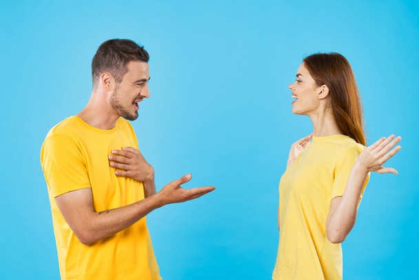 young beautiful couple in  t-shirts posing in studio on isolated background - Foto, Imagem