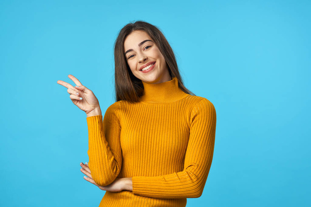 Young woman  with victory gesture   in studio isolated on blue background  - Fotografie, Obrázek