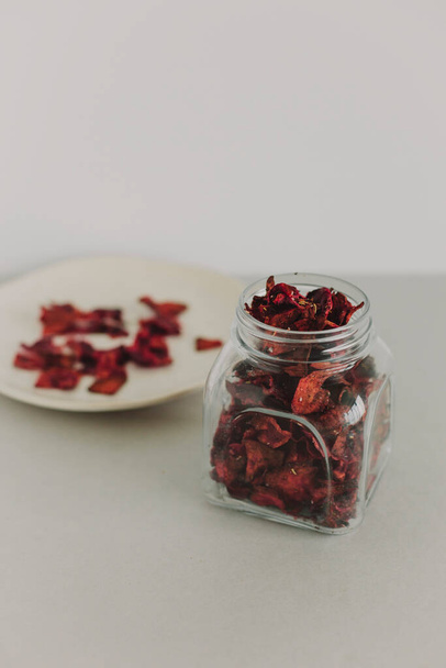 Crispy beetroot snack in a jar. In the background is a plate with pieces of beetroot. Healthy food - Фото, изображение