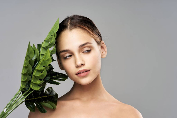 Young beautiful model posing with leaves in studio - Photo, Image