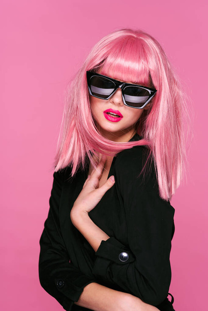 young beautiful woman in pink wig and sunglasses posing in studio  - Valokuva, kuva