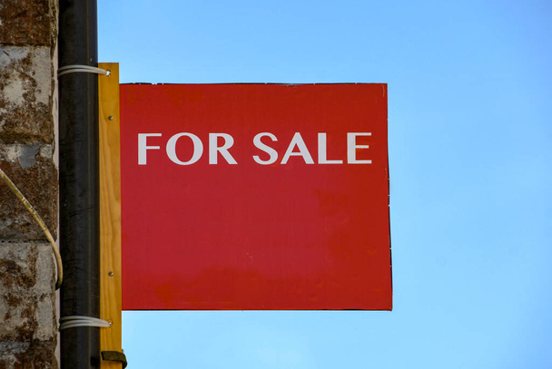 For sale sign on the wall of a commercial property isolated against blue sky. No people. - Photo, Image