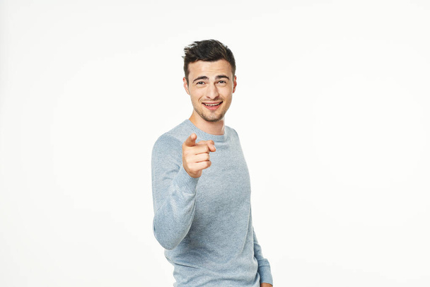 junger Mann zeigt mit dem Finger isoliert auf weißem Hintergrund  - Foto, Bild