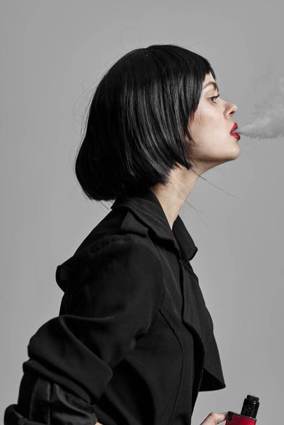 Young beautiful woman smoking in studio. Fashion photography  - Fotó, kép