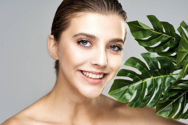 Молодая красивая модель позирует с листьями в студии
 - Фото, изображение