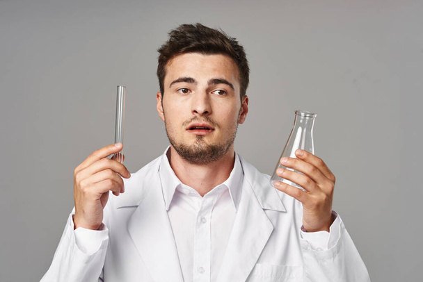Doctor confuso en bata de laboratorio con tubos de ensayo  - Foto, Imagen