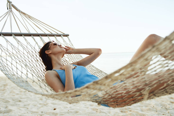 Young beautiful woman relaxing in hammock - 写真・画像