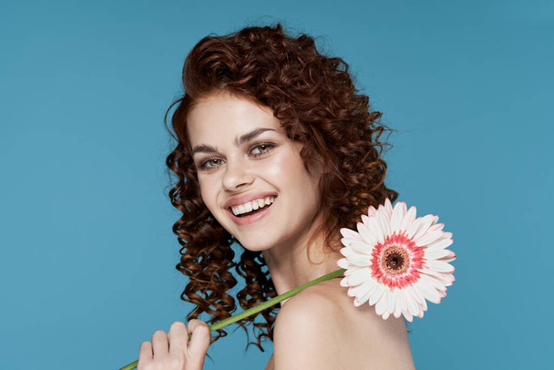 Young woman with flower posing in studio - Fotografie, Obrázek