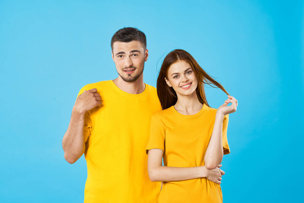 young woman and man standing  on blue background  - Φωτογραφία, εικόνα