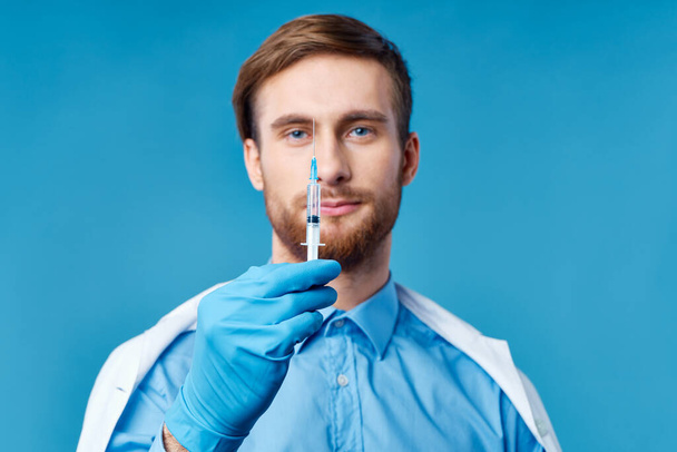 studio shot of male doctor showing syringe - Foto, imagen