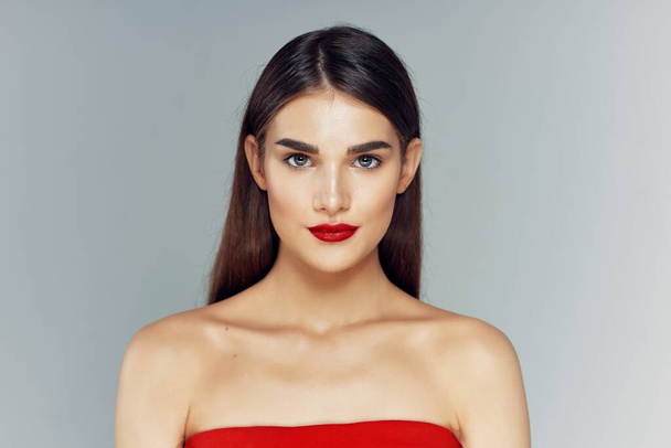 Portret van een mooie jonge vrouw met rode lippenstift op haar lippen. Schoonheid, mode fotografie  - Foto, afbeelding