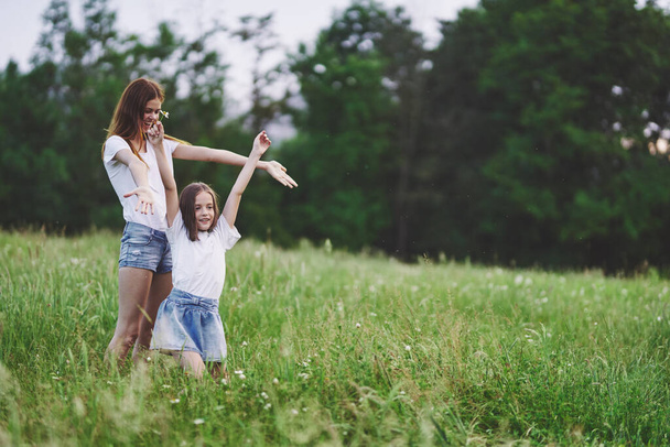 Mladá matka a její dcera se baví na heřmánku pole - Fotografie, Obrázek