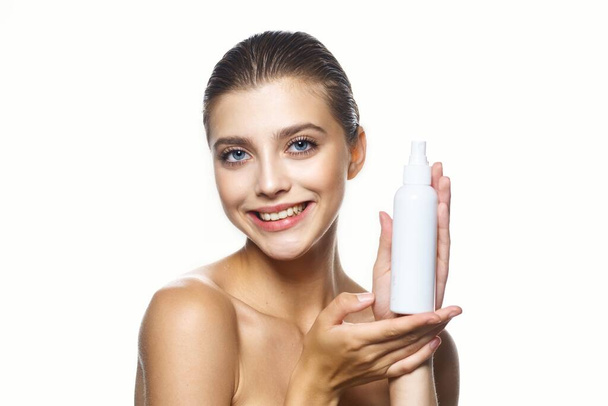 Στιγμιότυπο. Πορτρέτο της νεαρής όμορφης γυναίκας με το προϊόν ομορφιάς απομονωμένο σε λευκό φόντο - Φωτογραφία, εικόνα
