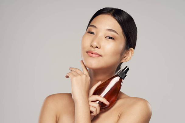 Young asian woman with hair spray in studio. Beauty, fashion photography - Φωτογραφία, εικόνα