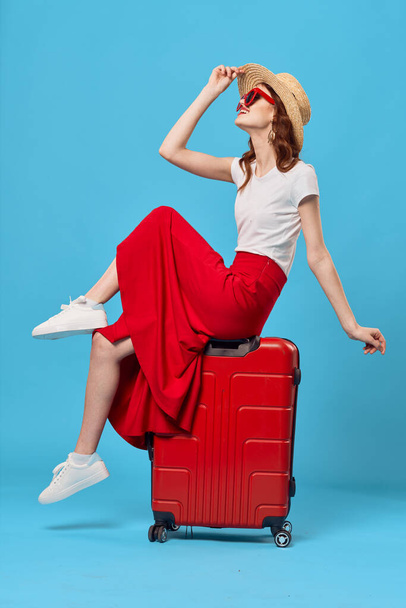 Young woman with red suitcase in studio - Fotó, kép