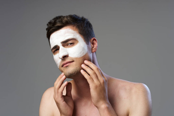 顔マスクを適用する若い男  - 写真・画像