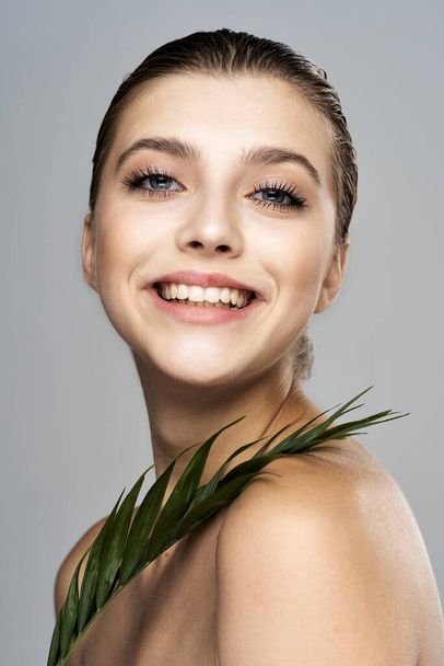 Young beautiful model posing with leaf in studio - Photo, Image