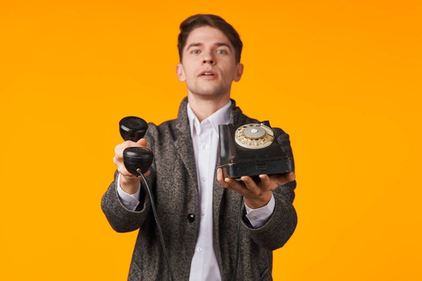 young man holding retro phone in studio - Fotografie, Obrázek