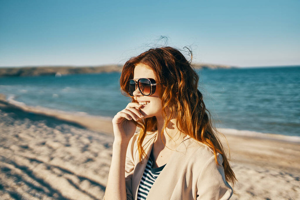 junge schöne Frau mit Sonnenbrille am Strand                                 - Foto, Bild